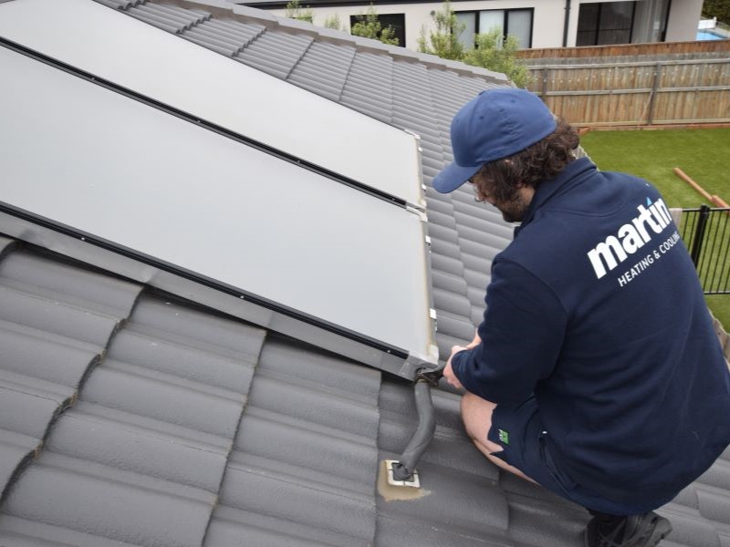 Technician fixing solar hot water panels